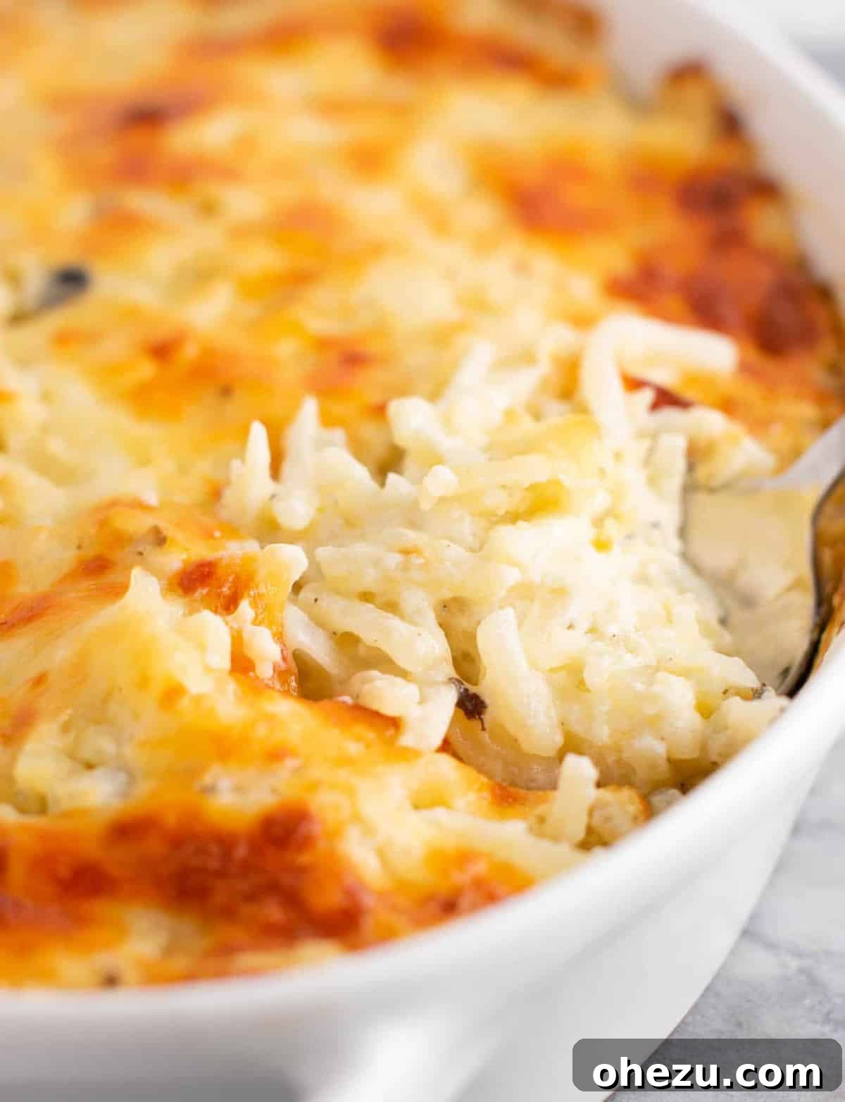 A golden-brown vegetarian hash brown casserole, fresh from the oven, ready to be served, showcasing its bubbly and cheesy top
