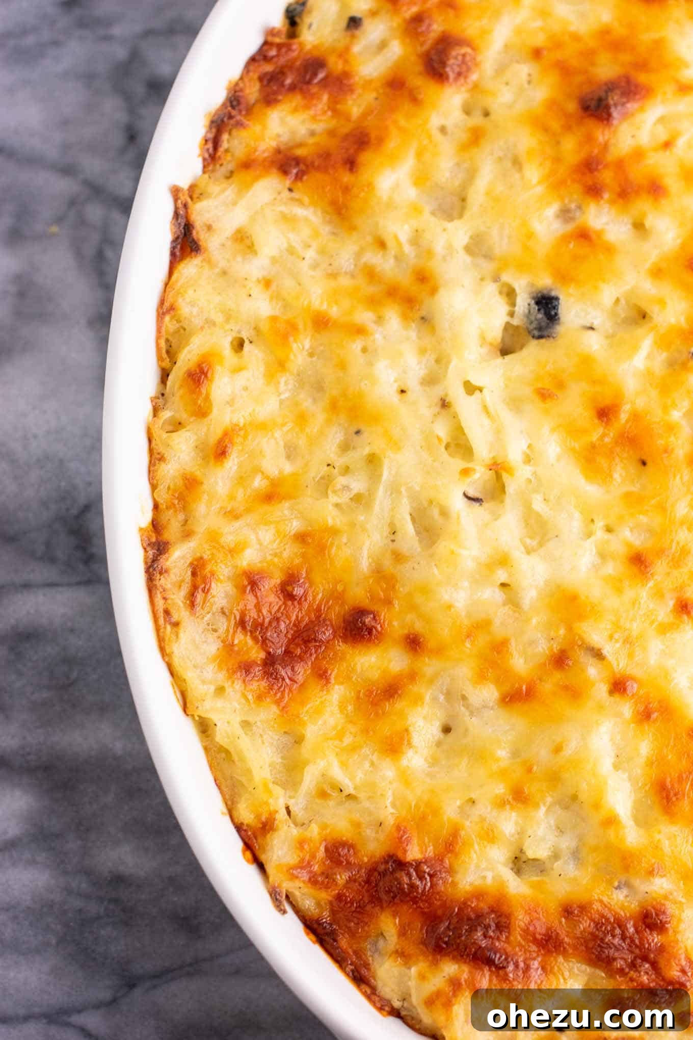 The creamy hash brown casserole mixture combined in a large bowl, showing its readiness for baking