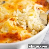 Spoon taking a scoop of vegetarian hash brown casserole, showing its creamy texture