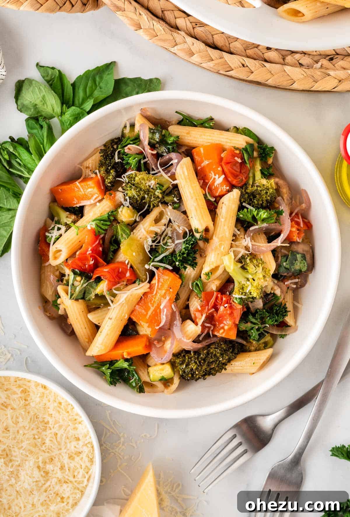 A close-up shot of roasted vegetable pasta served in a bowl, showcasing the vibrant colors and fresh herbs.