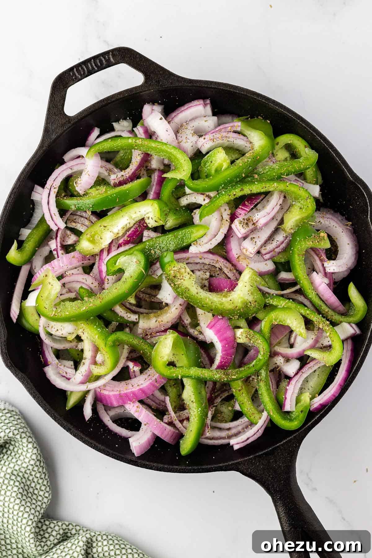 Zesty Fajita Medley 7 Mixing sliced vegetables with olive oil and spices in a hot skillet.