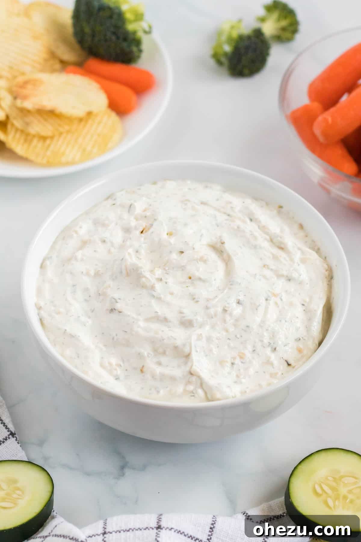 A close-up shot of the mixed sour cream dip, showing its rich texture and the vibrant green specks of chives and parsley within.
