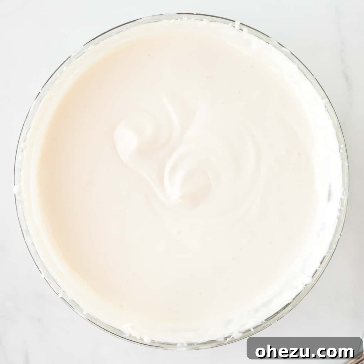 The finished yogurt fruit dip, fully mixed and smooth, resting in a glass bowl, ready for chilling.