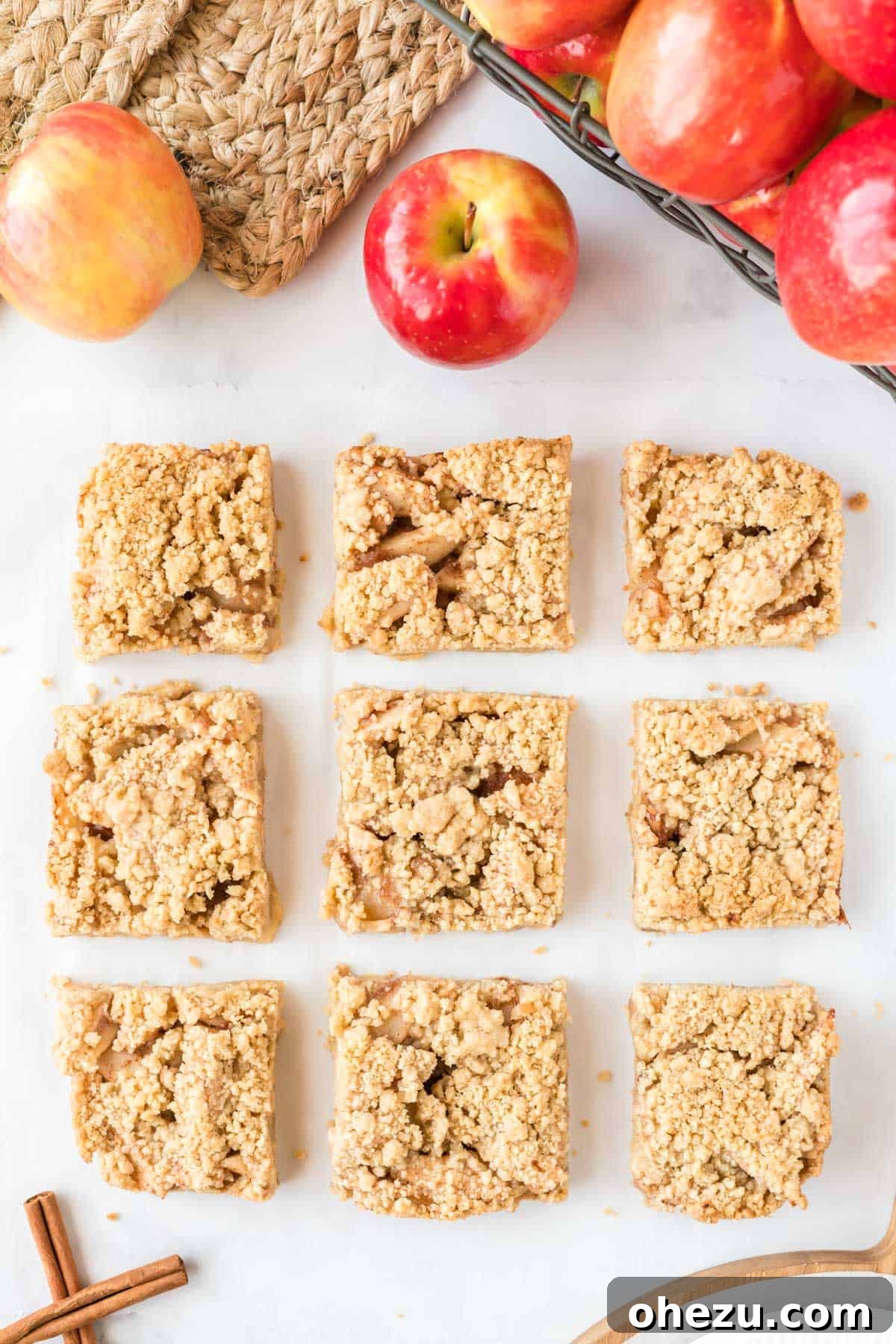 Apple crisp bars cut into 9 perfect squares in a white baking dish