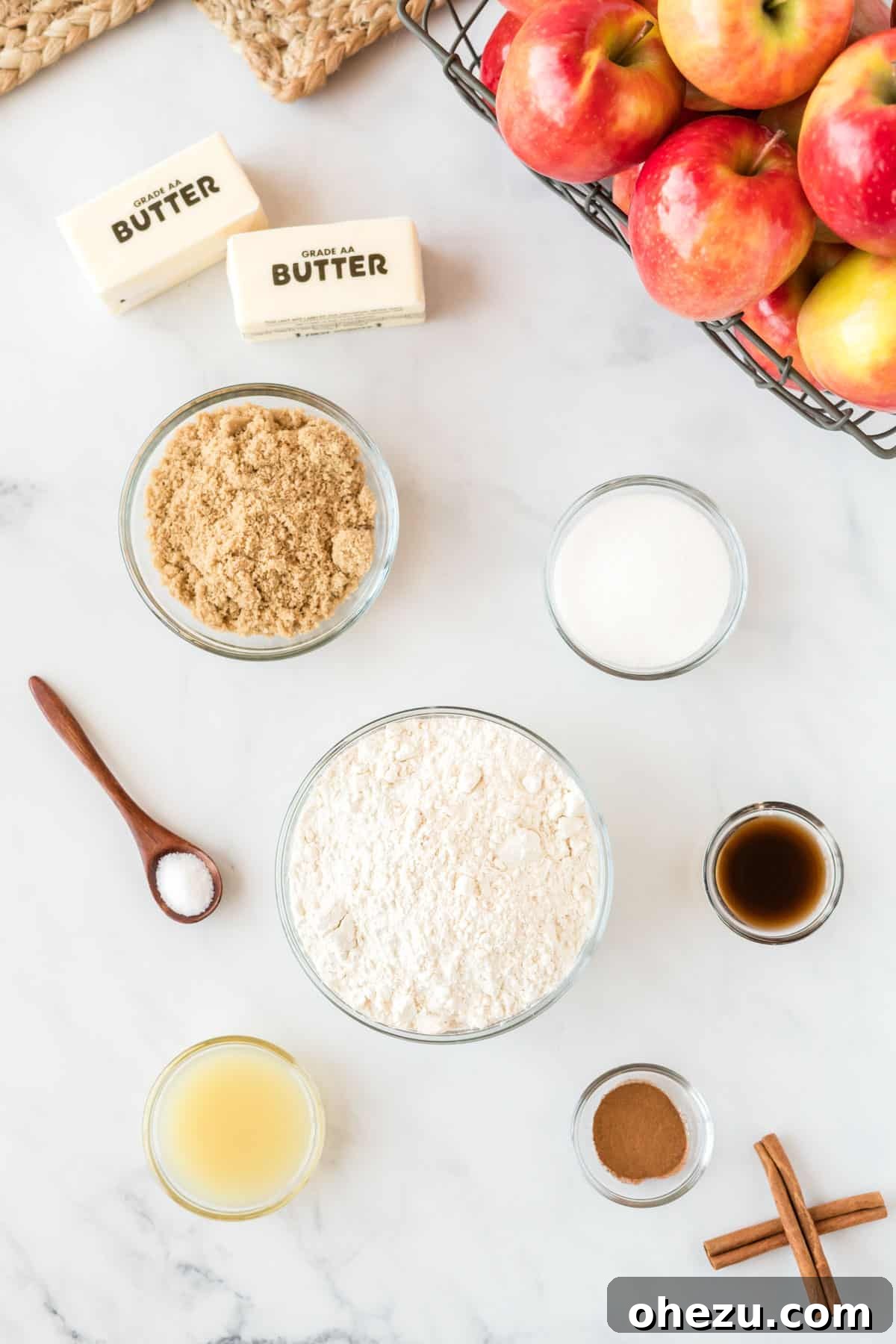 Bowls of prepped ingredients laid out for apple crisp bars: flour, sugars, butter, apples, spices, and lemon