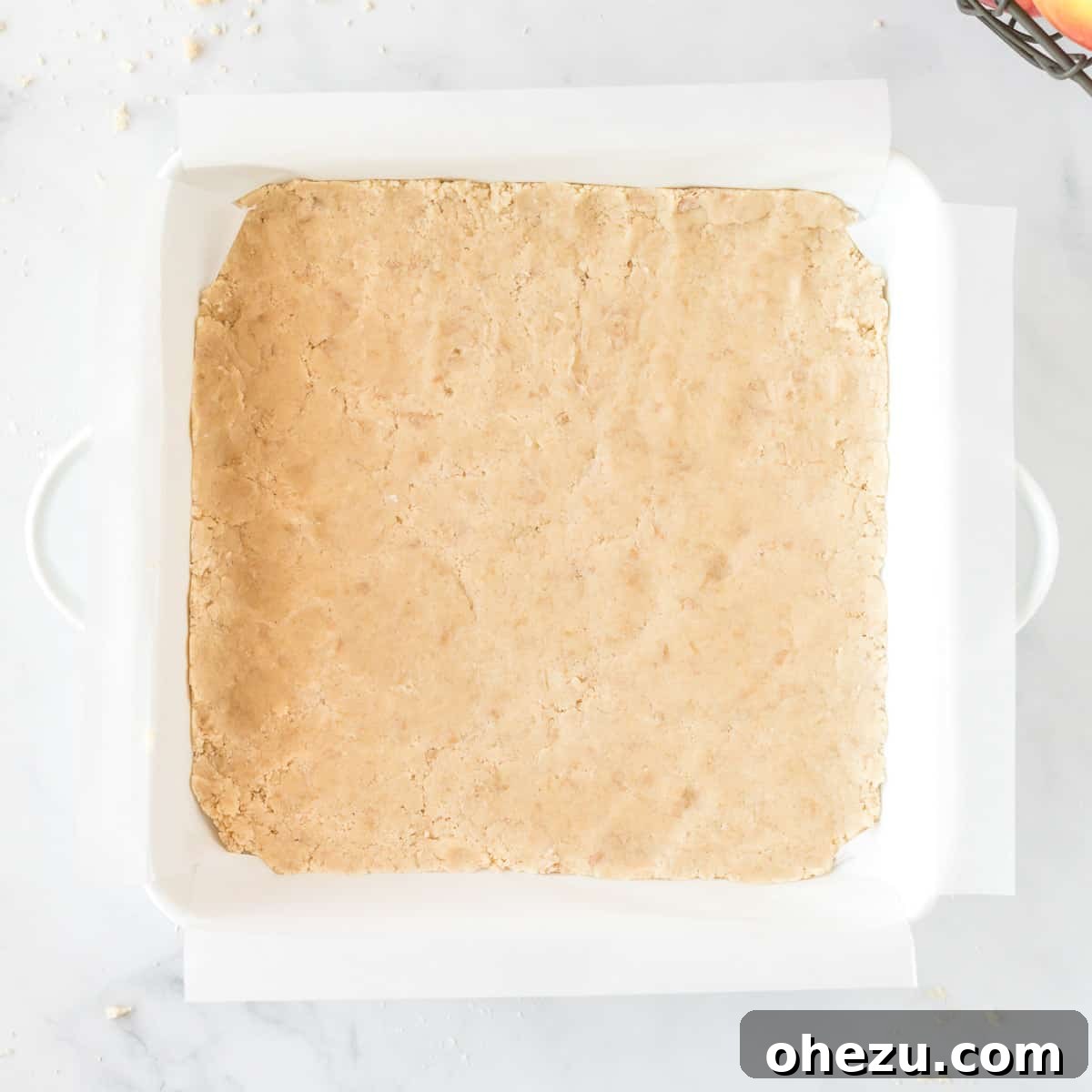 Baked shortbread crust in an 8x8 baking dish, golden and ready for the next layer