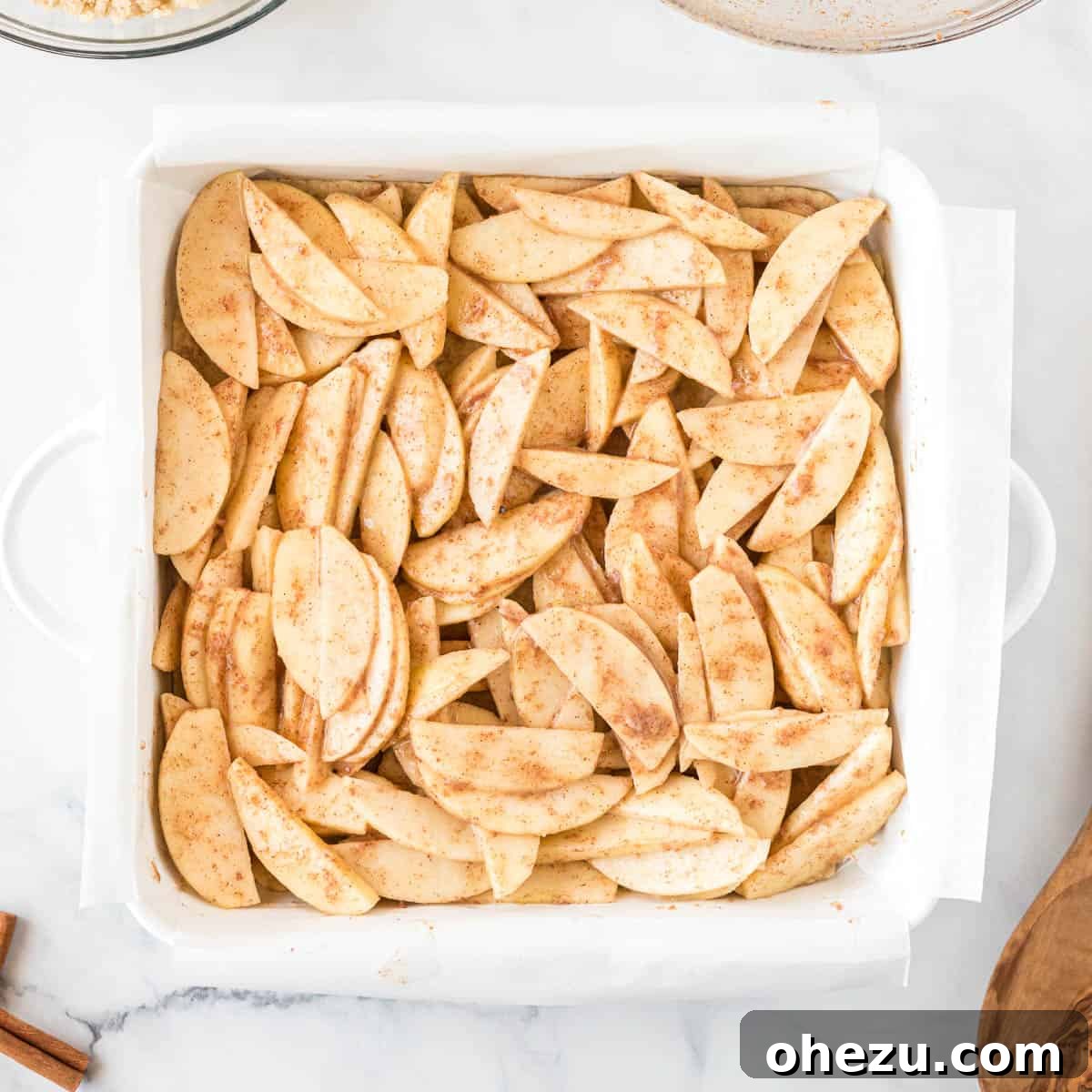 Spiced apple filling spread evenly over the pre-baked shortbread crust in a baking dish