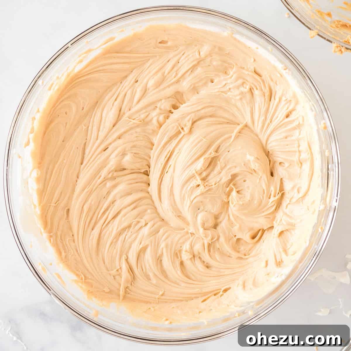 The fully combined no bake peanut butter pie filling, smooth, light, and creamy, presented in a mixing bowl after folding the whipped cream into the peanut butter mixture.