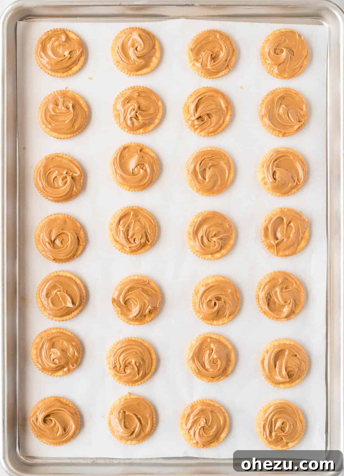 Peanut butter being spread onto Ritz cracker cookies
