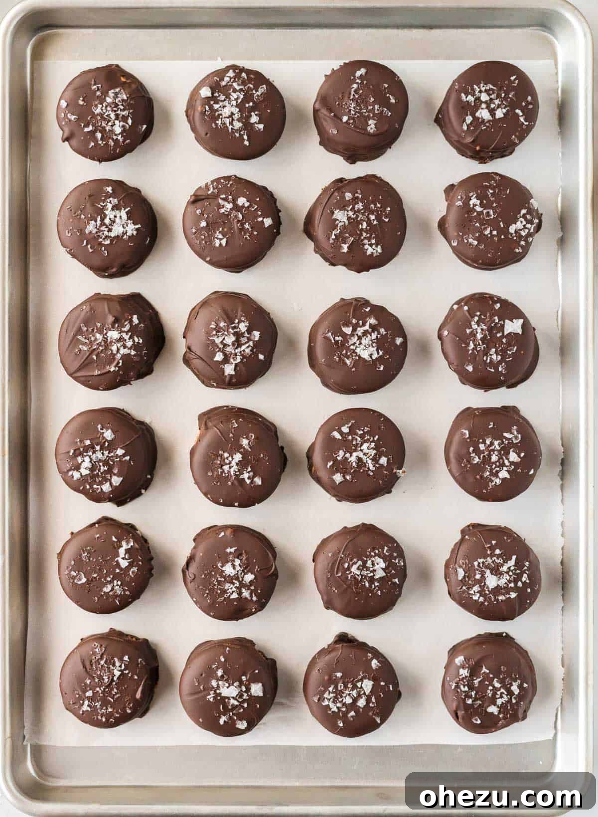 Chocolate-dipped Ritz cracker cookies on a baking sheet