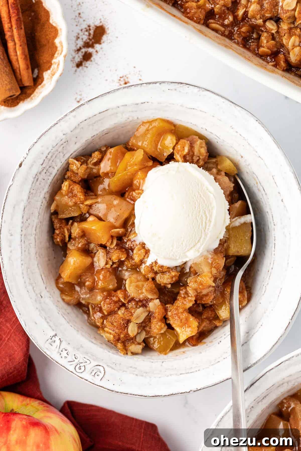 Warm vegan apple crisp topped with a melting scoop of vanilla ice cream, ready to be served.