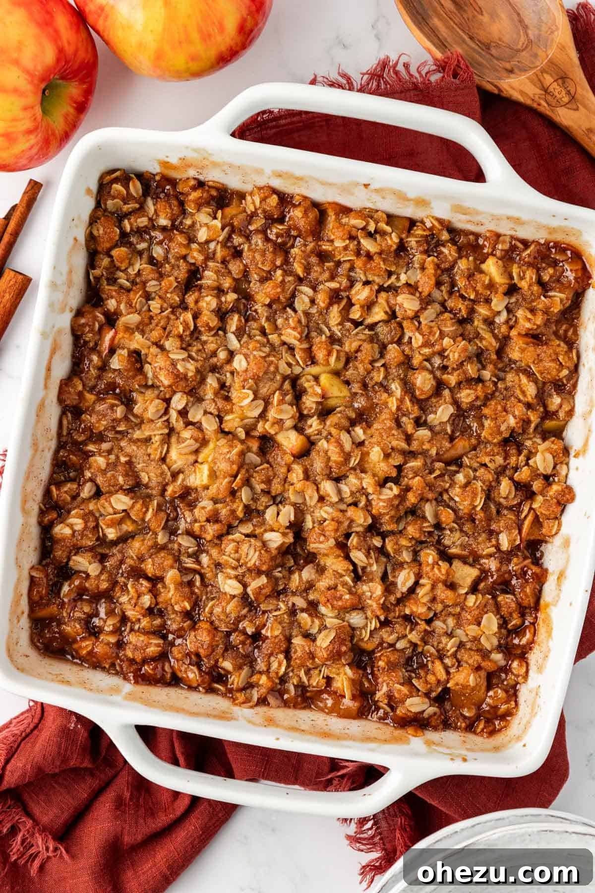 A perfectly baked vegan apple crisp in a baking dish, golden brown and bubbly from the oven.