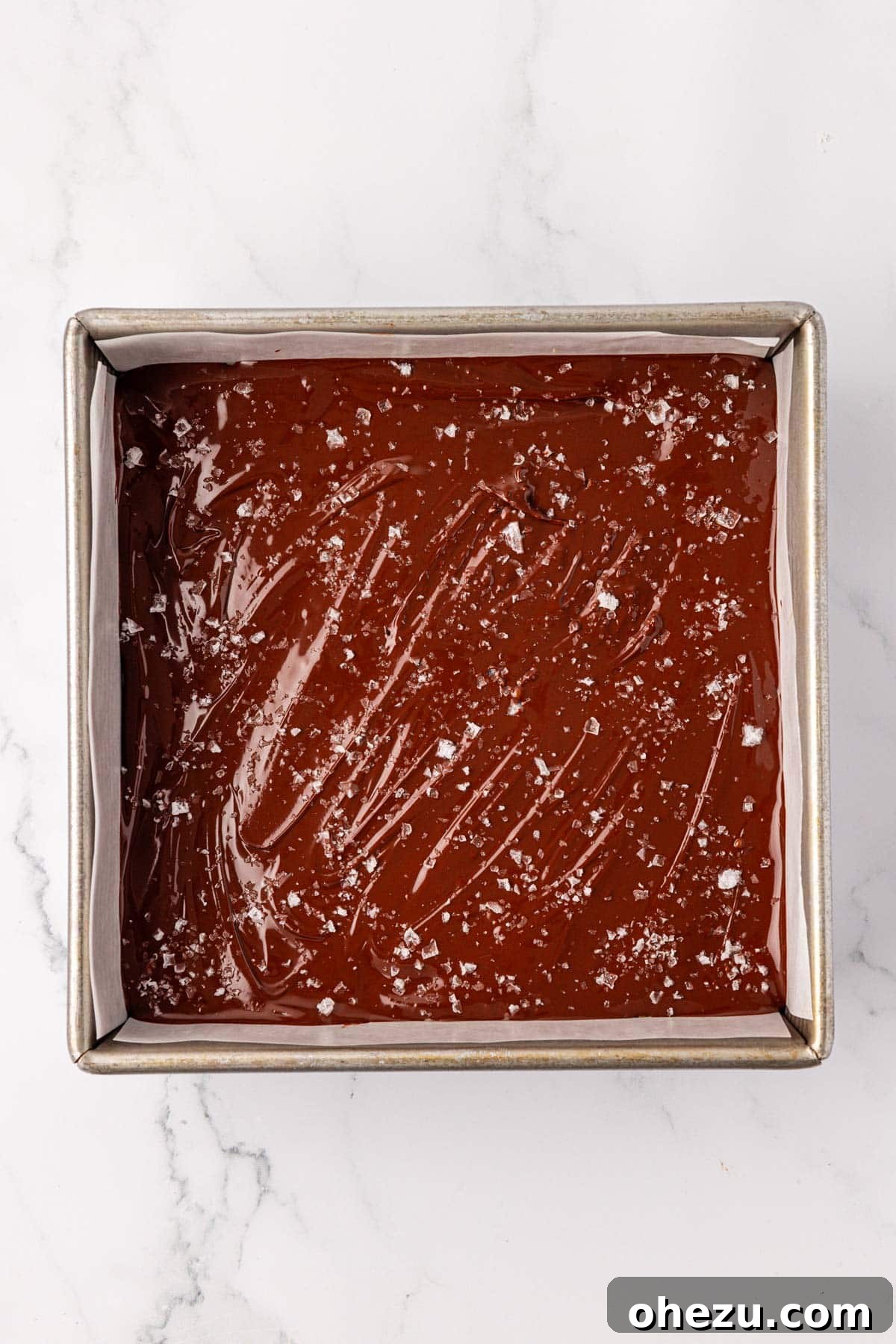 Sprinkling flaked sea salt over the melted chocolate layer of the protein bars
