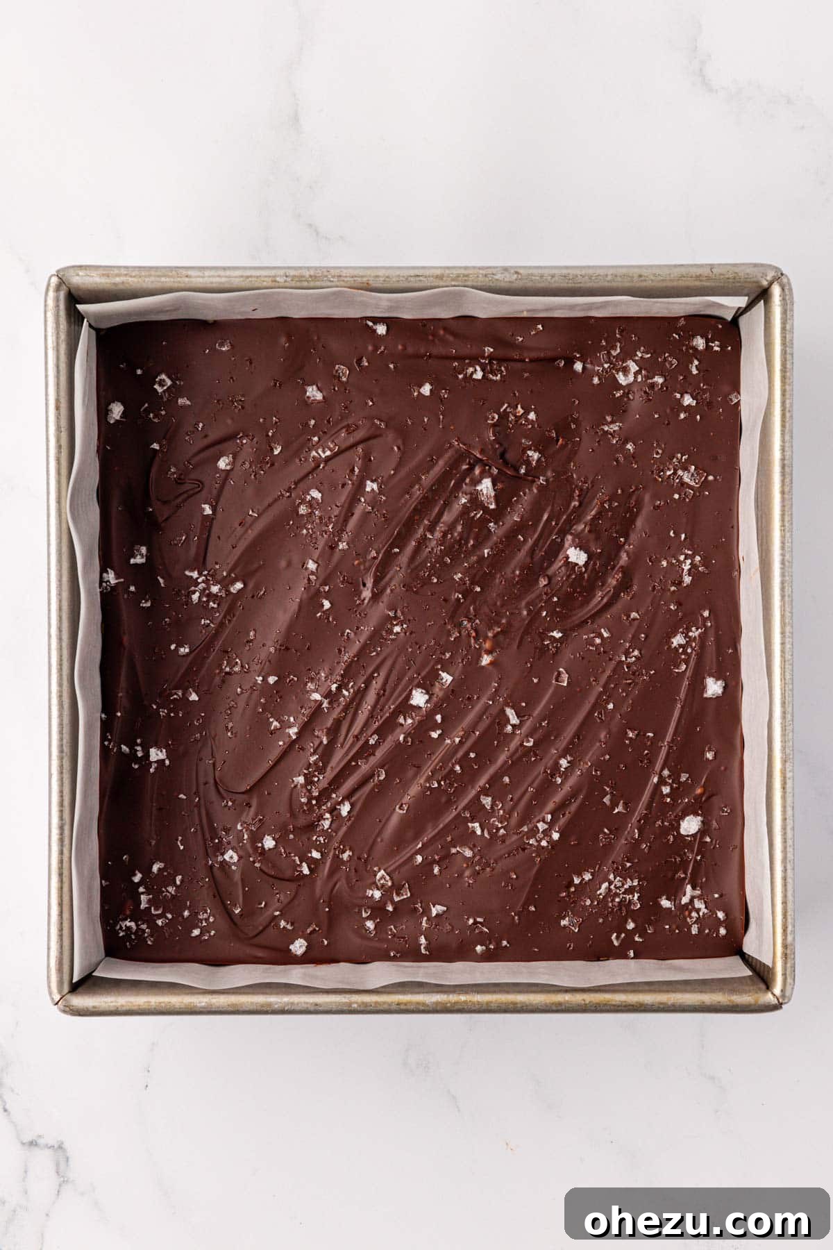 No bake protein bars chilling in the pan with chocolate and sea salt topping
