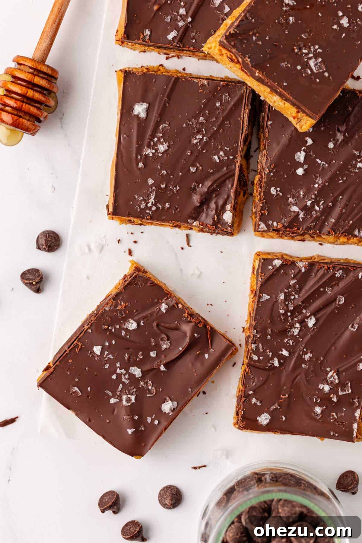 A close-up of a no bake protein bar, showing the texture of the oat and peanut butter base topped with chocolate and sea salt
