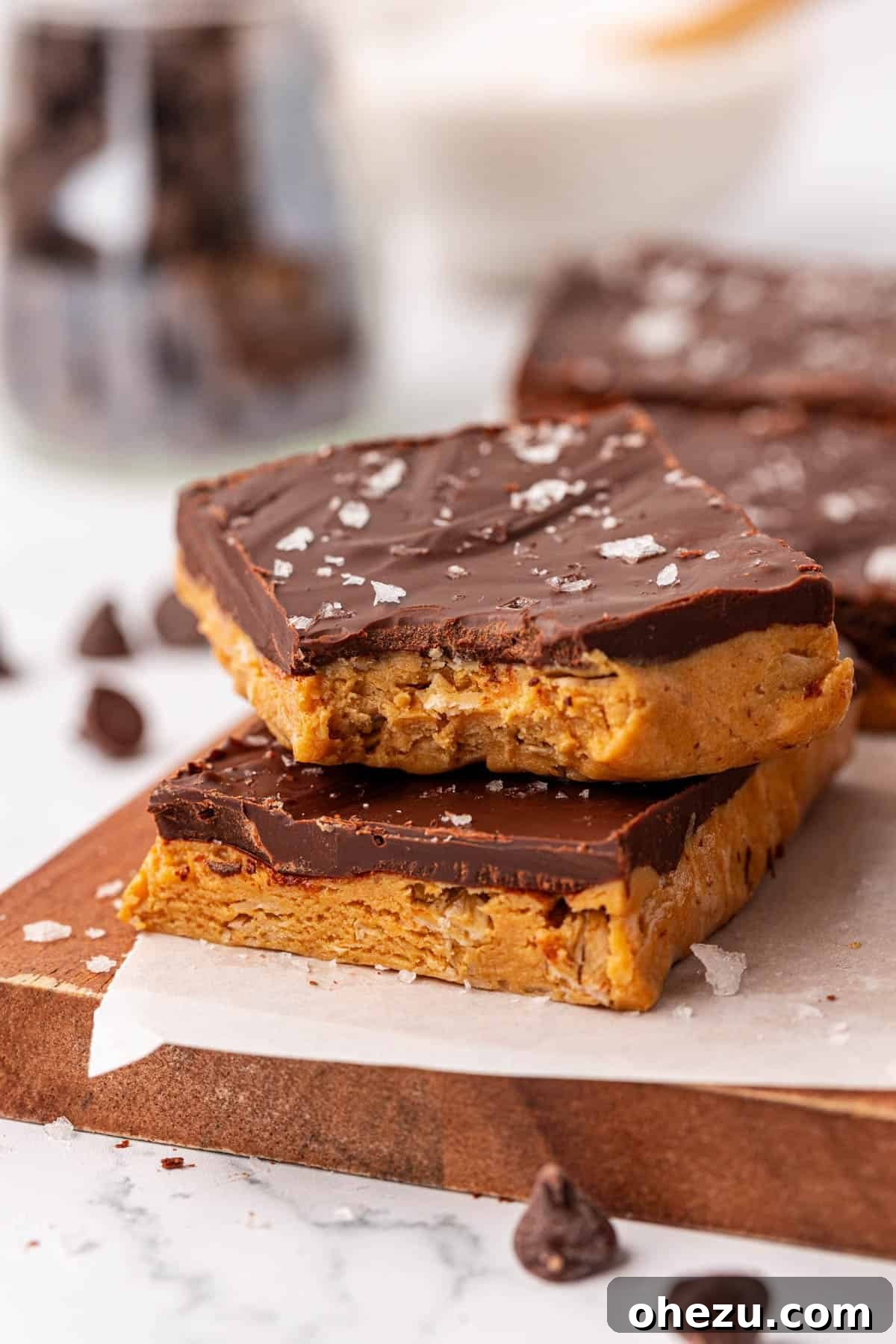 A close up of three no bake protein bars stacked on top of each other, ready to be enjoyed