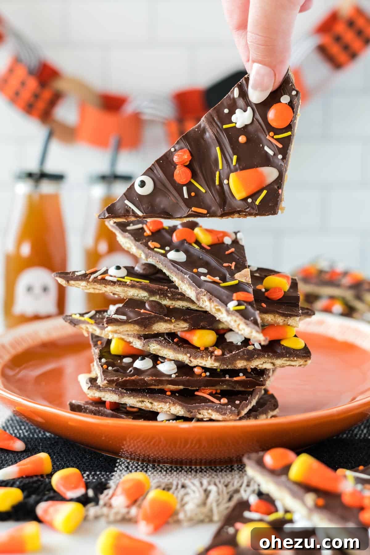 Another beautiful shot of Halloween crack candy pieces stacked invitingly on an orange plate, emphasizing its appeal.