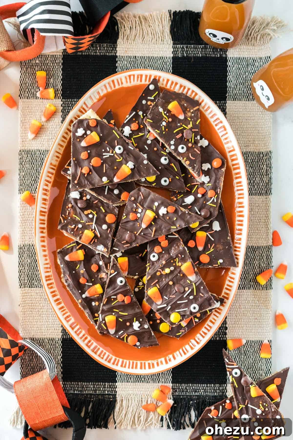A closer look at Halloween crack candy on an orange serving plate, showcasing the details of the candy and sprinkles.
