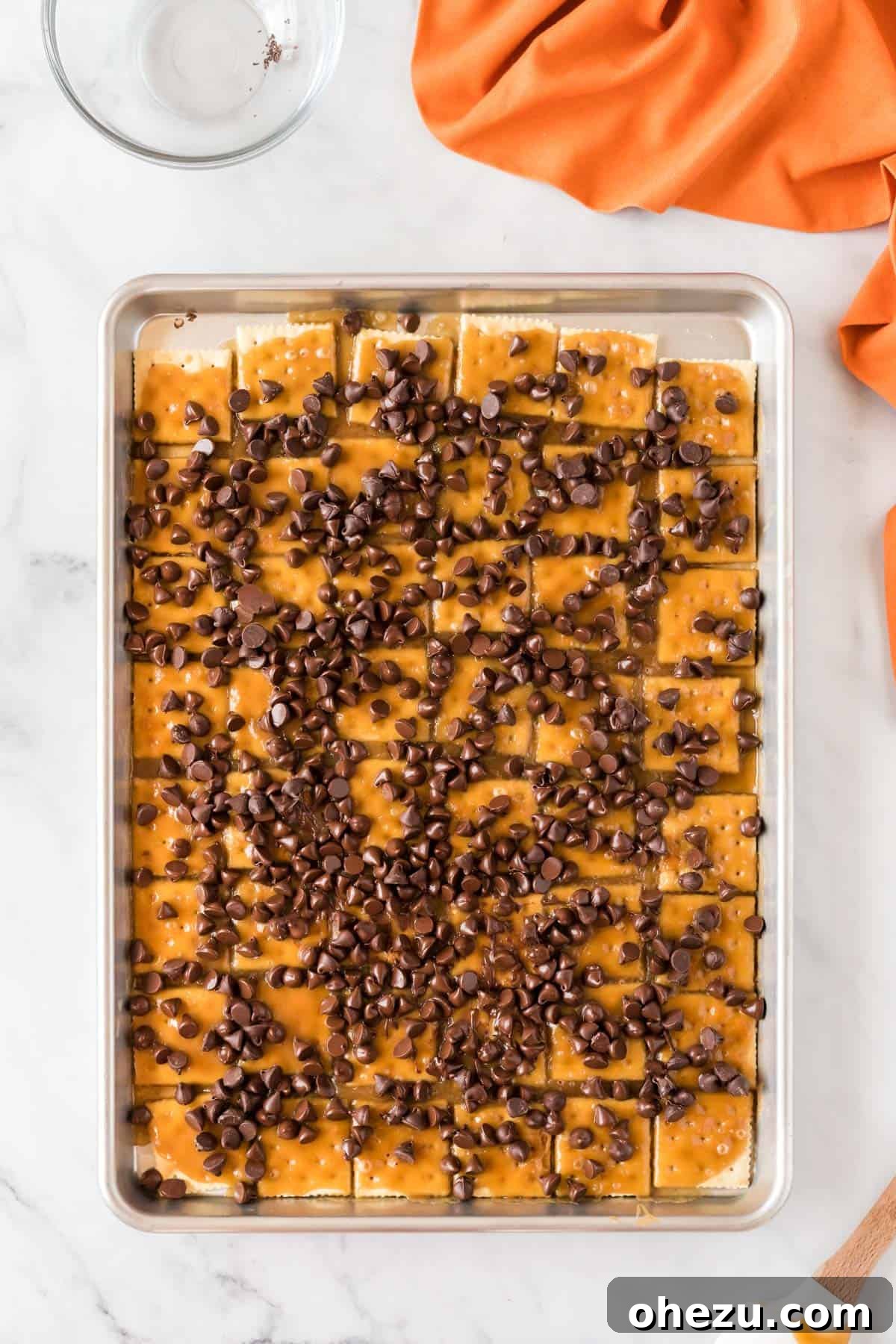 Semi-sweet chocolate chips sprinkled over the warm, baked Halloween crack base, starting to melt.