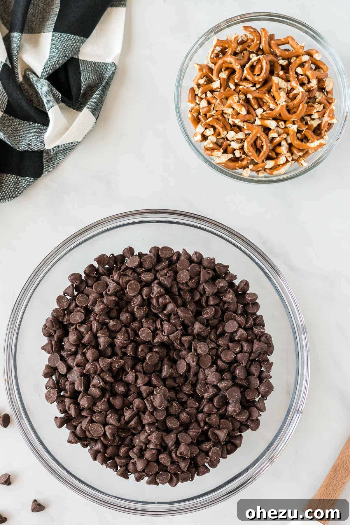 Chocolate chips and crushed pretzels in separate bowls