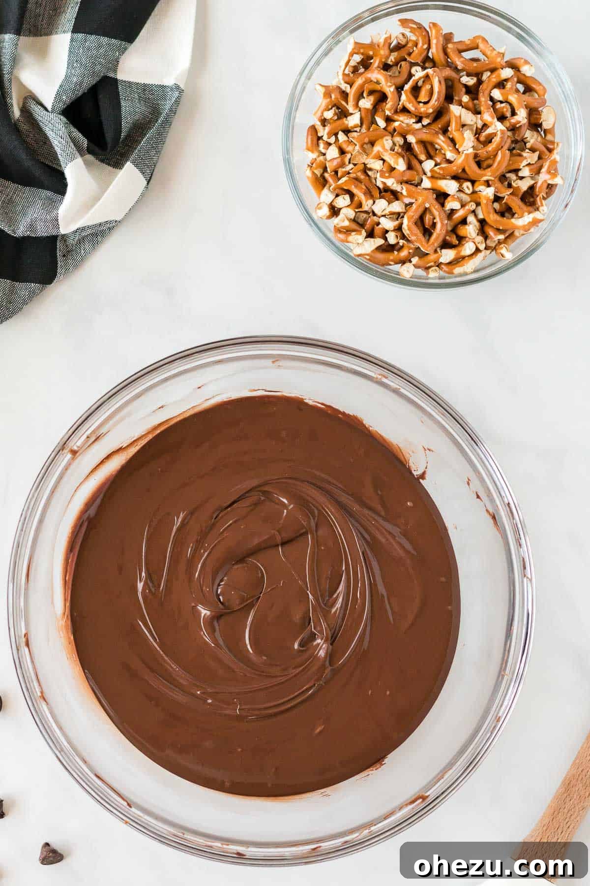 Melted chocolate next to crushed pretzels