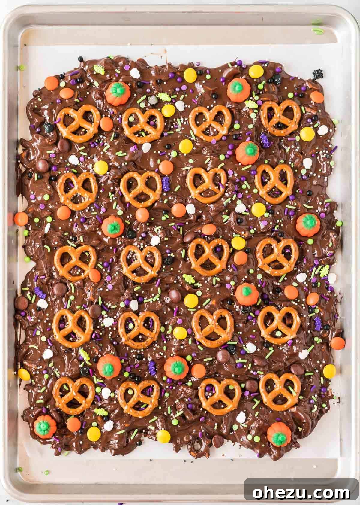 Decorating the Halloween bark with various candies and sprinkles