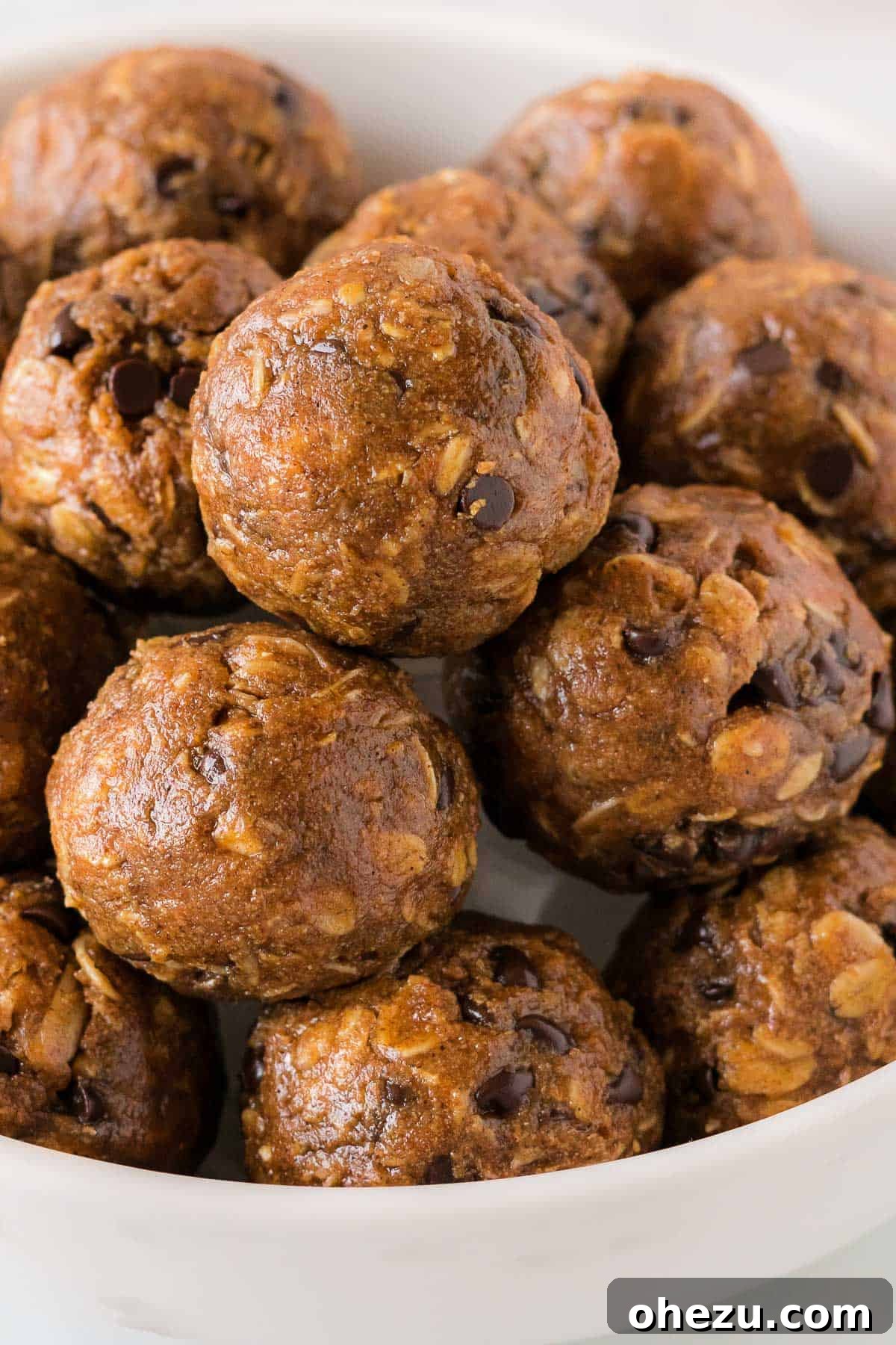 Stacked pumpkin energy balls in a rustic bowl, garnished with a sprinkle of cinnamon, capturing the essence of a healthy fall treat.