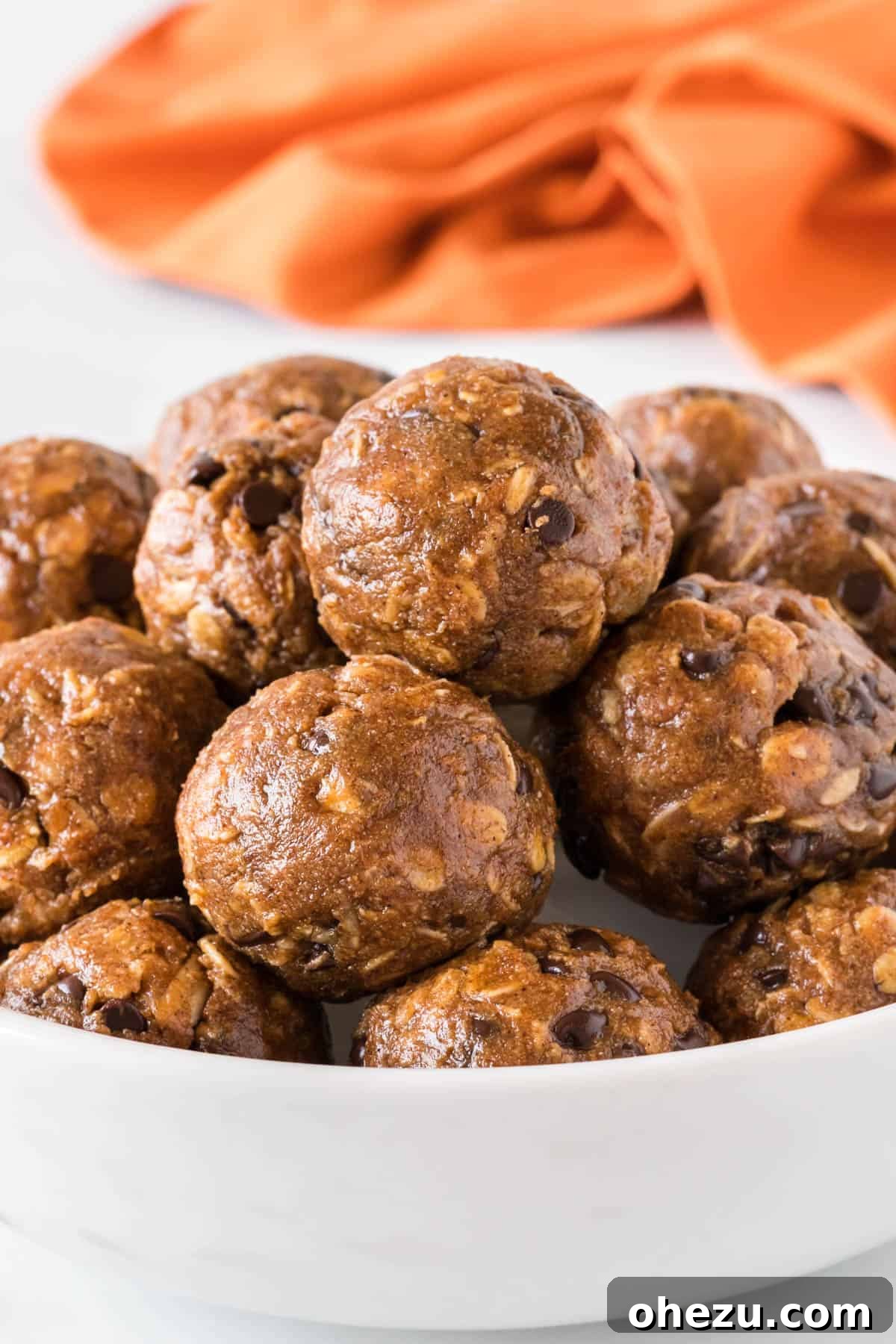 A bowl filled with numerous pumpkin energy balls, perfectly stacked and ready to be enjoyed as a wholesome snack.