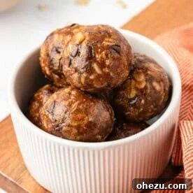 Close-up image of two pumpkin protein balls, highlighting their texture and appealing color against a soft background.