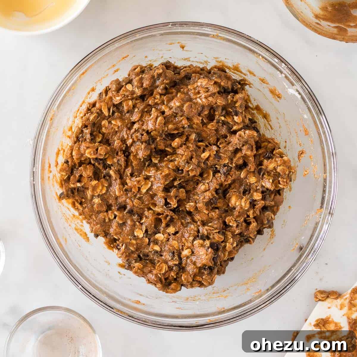 The fully mixed energy ball dough in a bowl, studded with mini chocolate chips, ready for shaping.