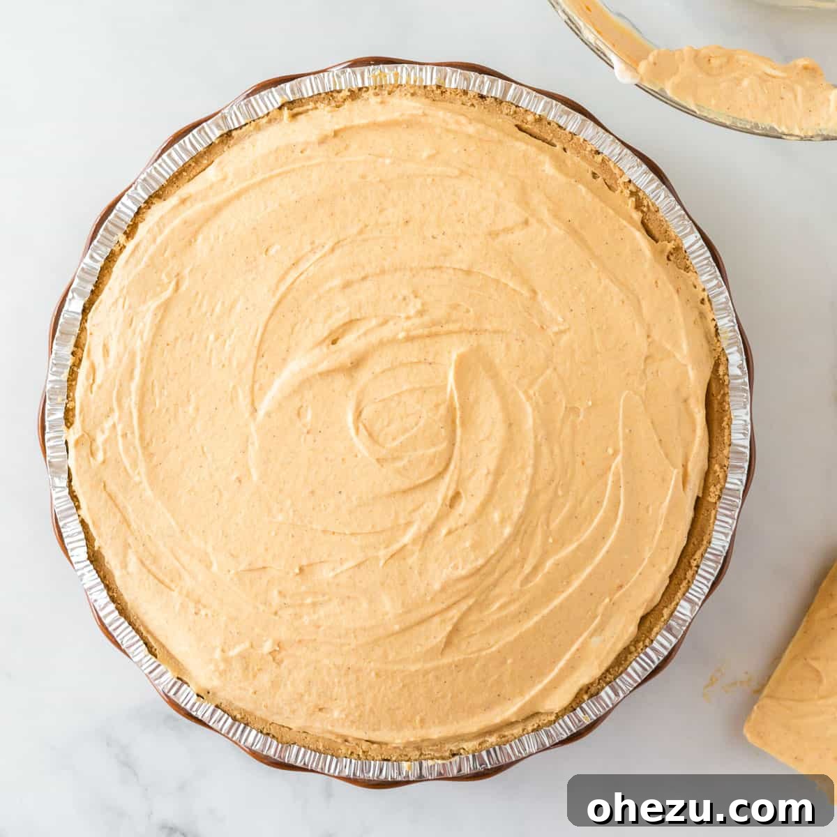 Velvet Pumpkin Pie 11 The pumpkin pie filling smoothly spread and leveled within the graham cracker crust.