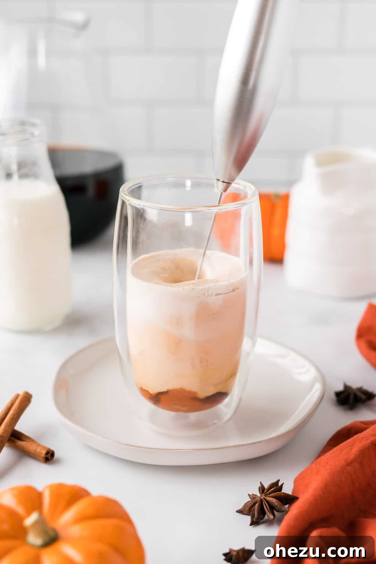 Spiced Pumpkin Cold Brew 5 A handheld milk frother actively mixing the pumpkin cream ingredients in a cup, creating a rich, frothy texture for the cold foam.