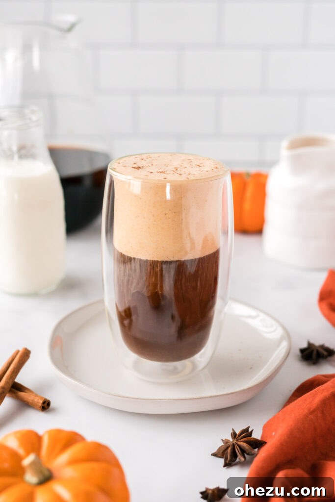 Spiced Pumpkin Cold Brew 9 A tall glass of cold brew coffee, beautifully topped with a generous layer of pumpkin cream cold foam, ready to be stirred.