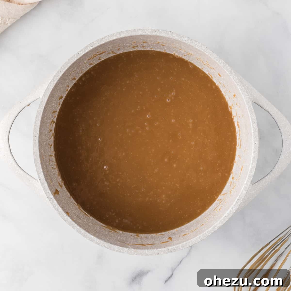 A saucepan on a stovetop, capturing the moment of golden brown toffee bubbling gently and steadily, indicating it has reached the ideal consistency and is nearly ready for the next stage.
