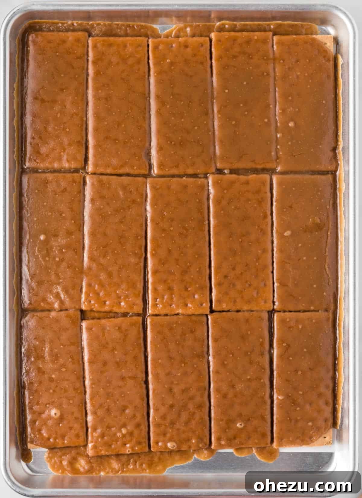 Graham crackers freshly removed from the oven, glistening with a bubbling, beautifully browned toffee layer, emanating a rich, sweet aroma.
