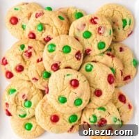 Close-up of a festive cake mix Christmas cookie on a white platter, highlighting its colorful M&M's.