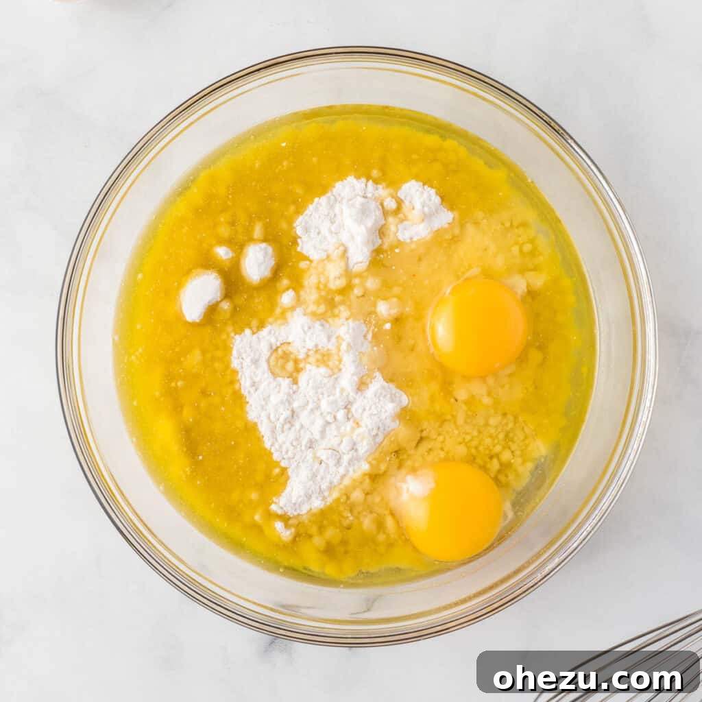 Holiday Cookie Magic from a Box 5 Yellow cake mix, eggs, and oil in a mixing bowl before combining into a festive Christmas cookie dough.