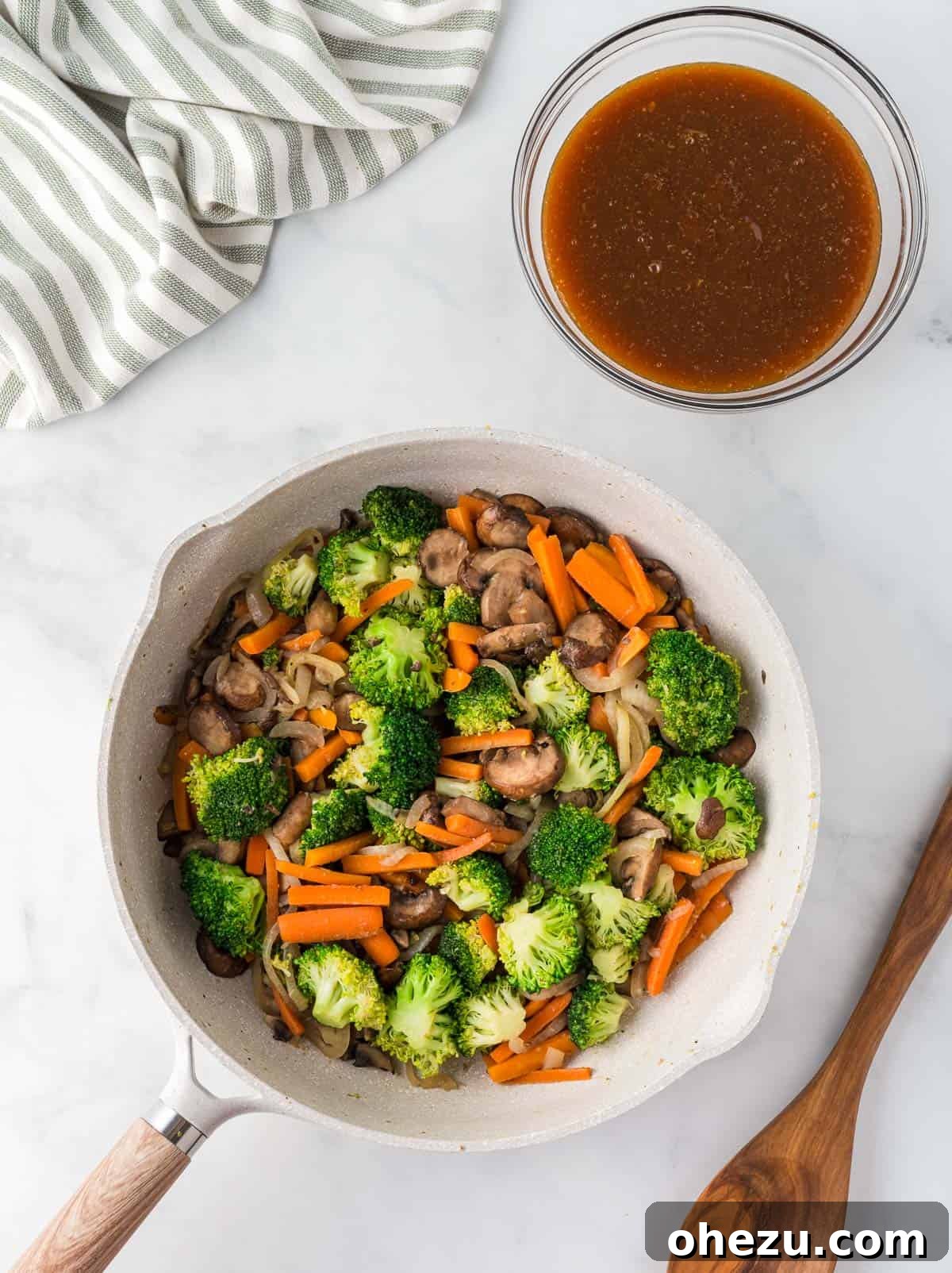 Perfectly cooked, vibrant vegetables simmering in a skillet, positioned next to a bowl of rich, homemade teriyaki sauce, ready to be poured and combined.