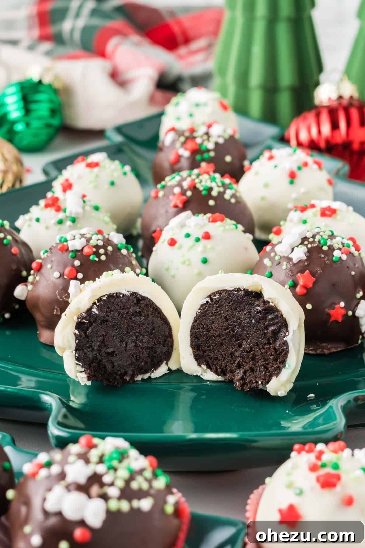 Decadent Holiday Oreo Treats 2 Christmas oreo ball cut in half to show the fudgy cream cheese and Oreo filling