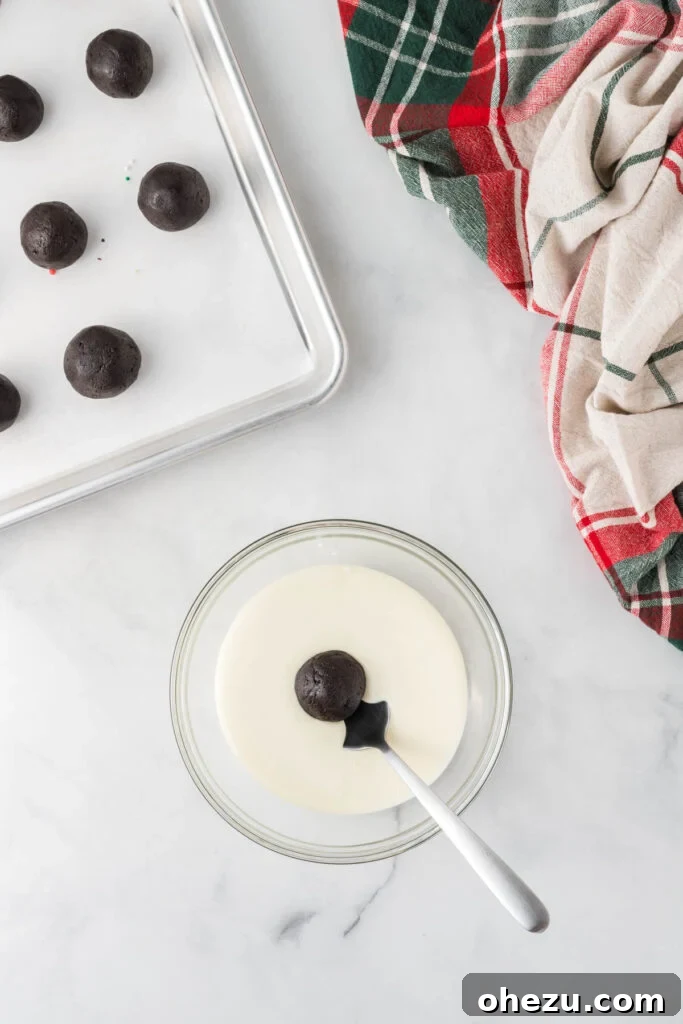 Decadent Holiday Oreo Treats 14 An Oreo truffle being dipped into smooth melted vanilla wafers