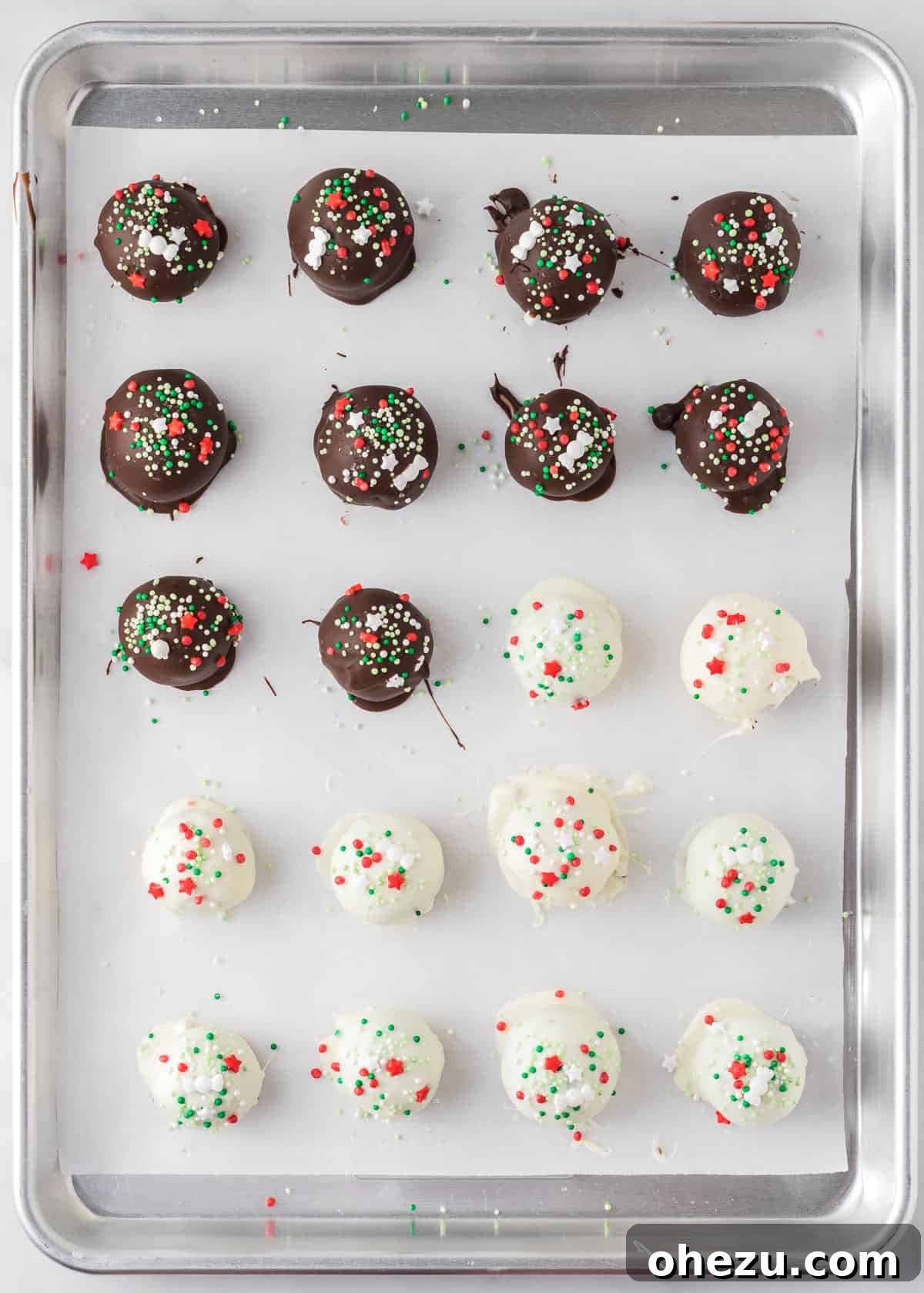 Decadent Holiday Oreo Treats 15 A baking sheet filled with an assortment of dark and white chocolate-dipped Oreo balls, covered in Christmas sprinkles