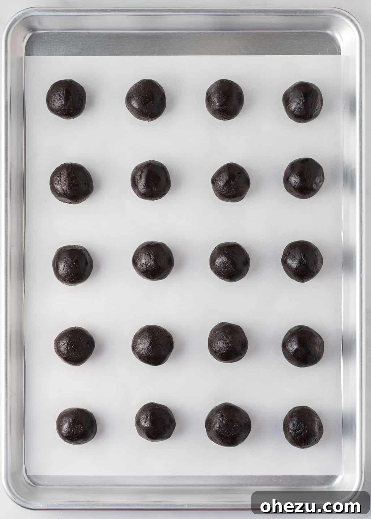 Decadent Holiday Oreo Treats 10 Neatly rolled Oreo balls arranged on a parchment paper-lined baking sheet