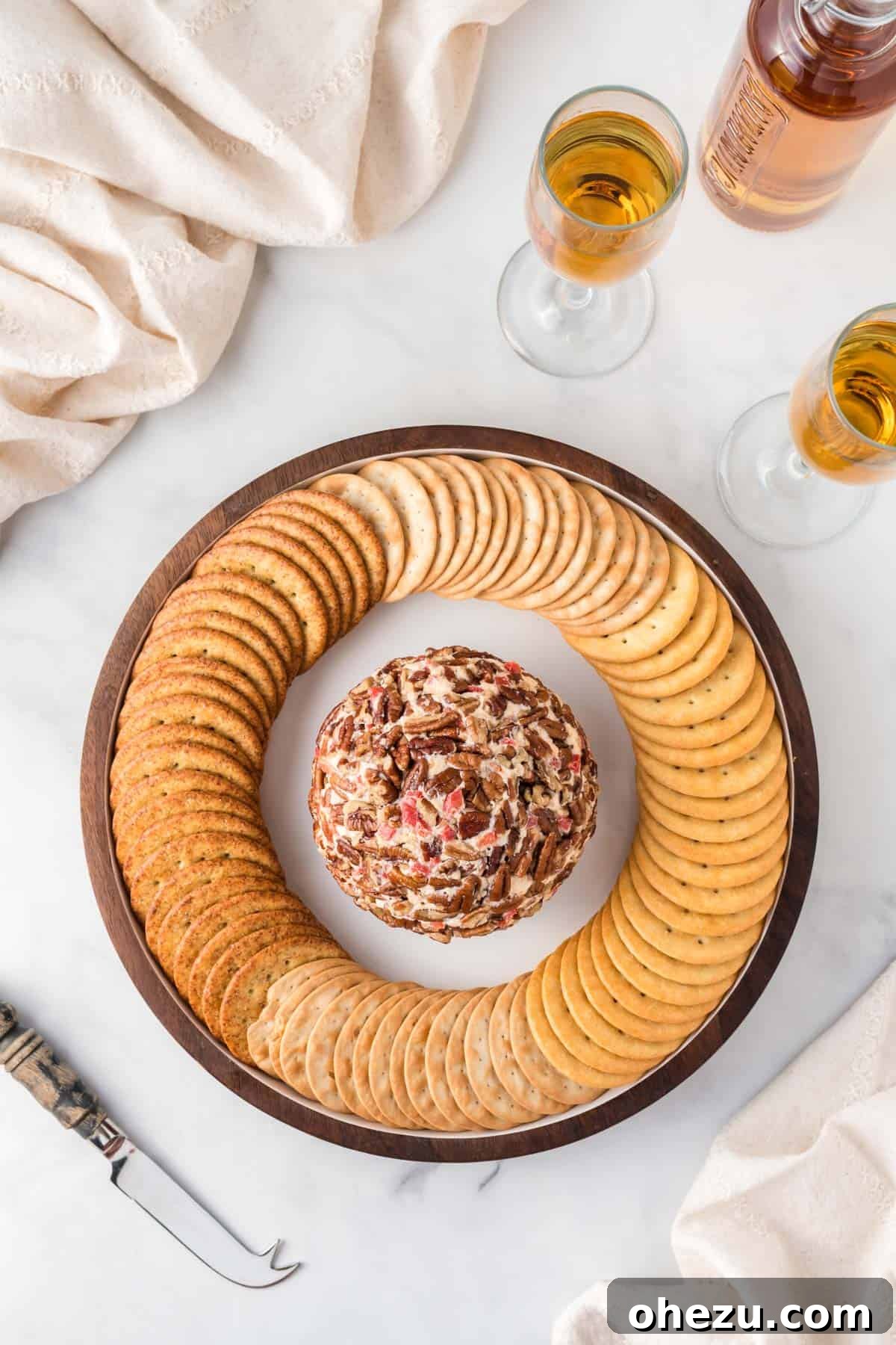 pimento cheese ball artfully arranged on a platter surrounded by an array of crackers