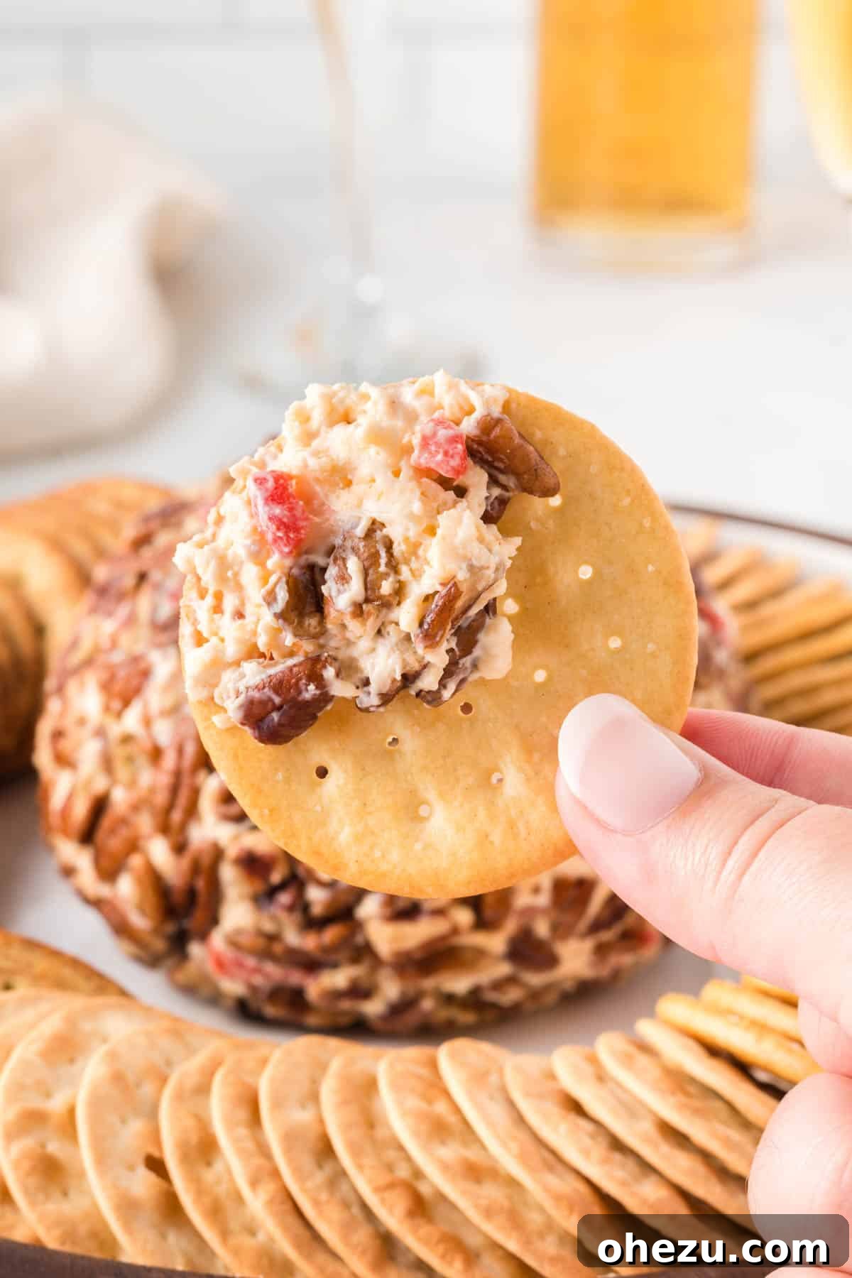 a cracker generously topped with a scoop of pimento cheese ball mixture