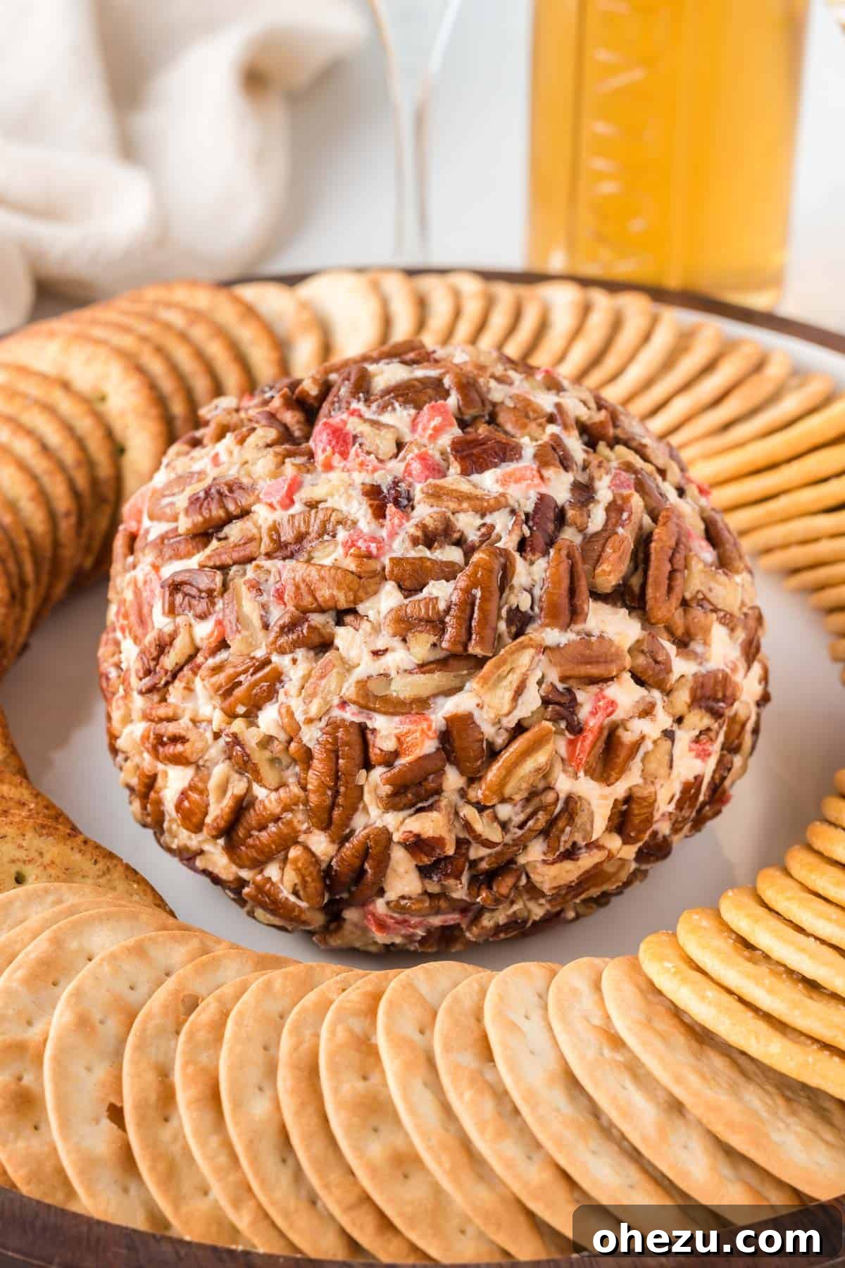 another view of the pimento cheese ball on a platter, surrounded by various crackers, ready to be served