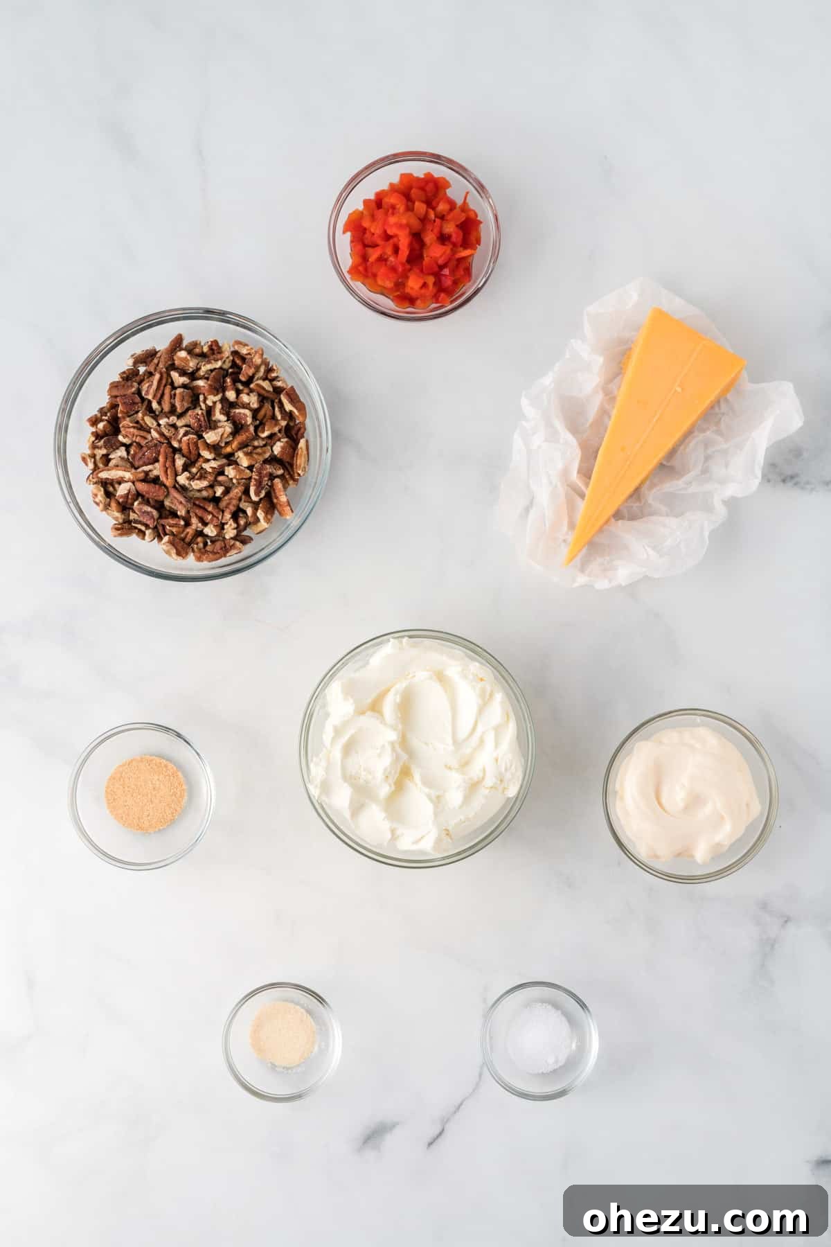 arranged ingredients including grated cheese, cream cheese, pimento peppers, mayo, and spices ready to make a pimento cheese ball
