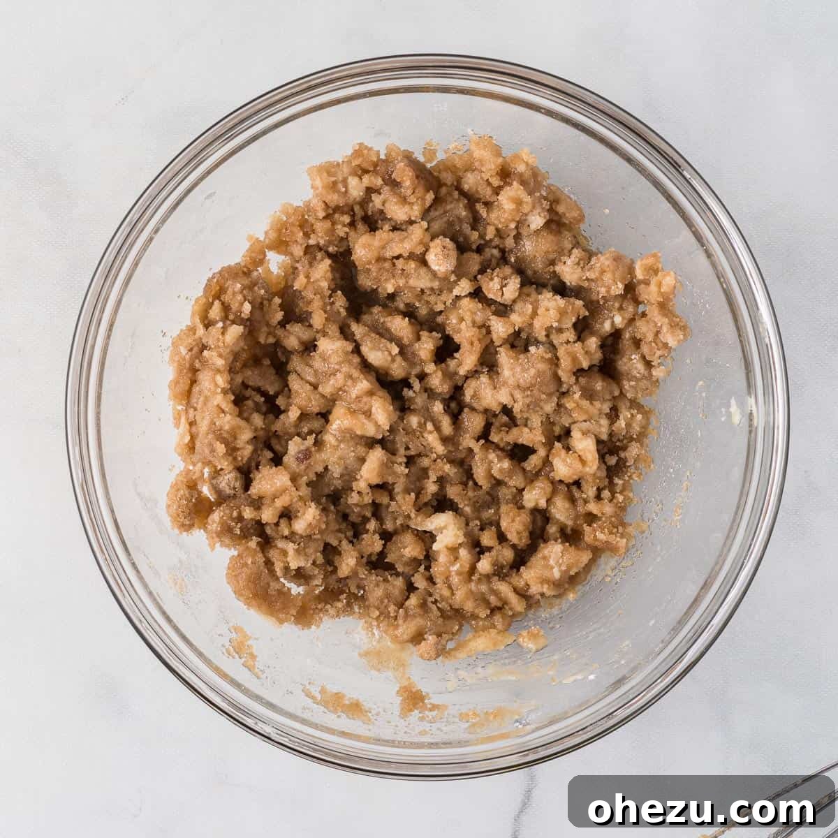 The fully mixed streusel topping, showing a perfectly crumbly texture resembling wet sand
