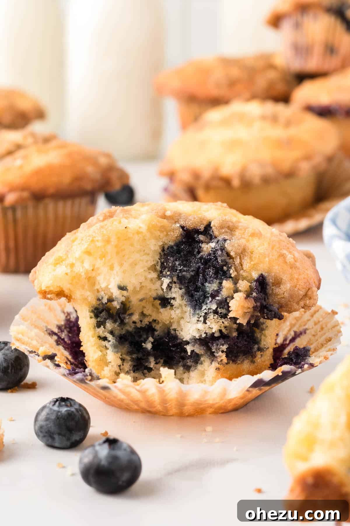 A perfectly baked cake mix blueberry muffin with a bite taken out, showcasing the moist interior and scattered blueberries