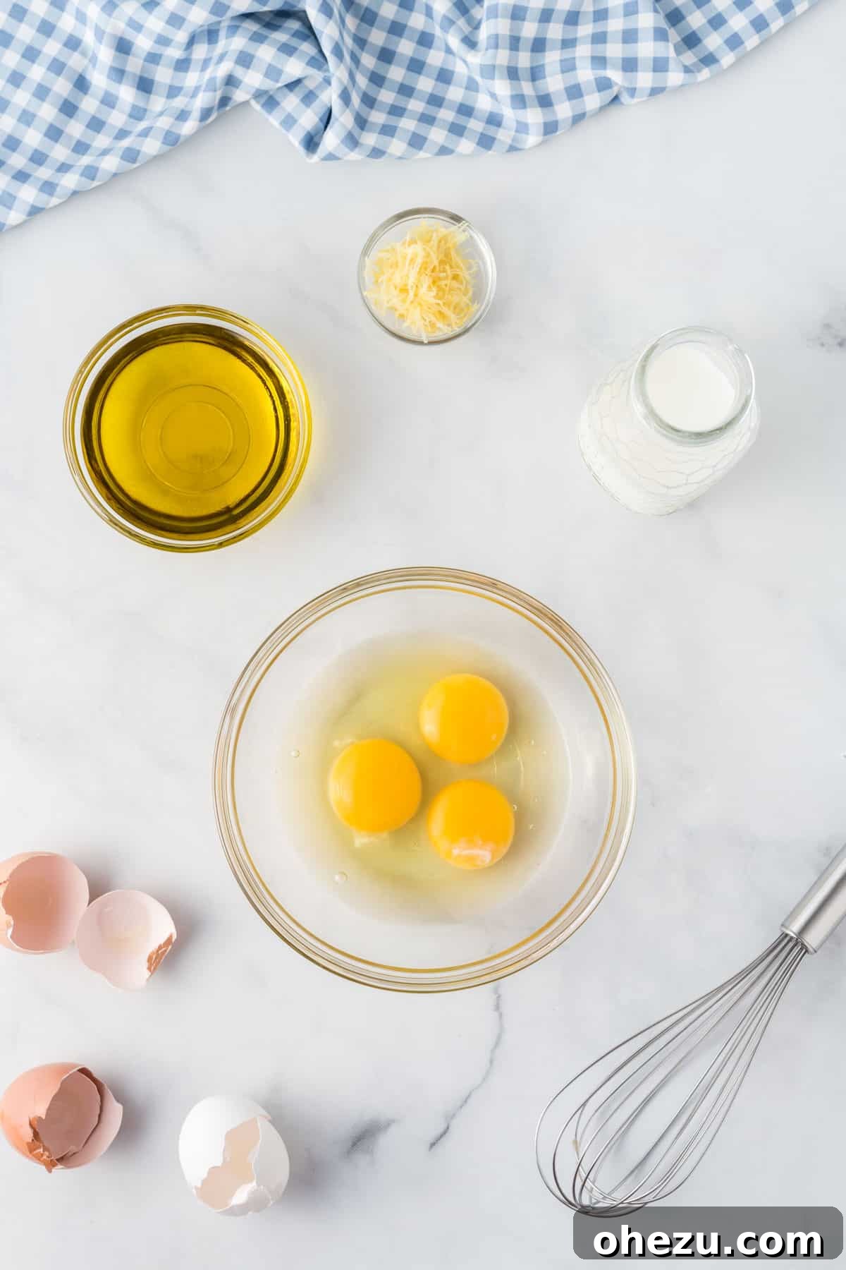 Separate small bowls containing eggs, olive oil, lemon zest, and milk, ready to be combined for the muffin batter