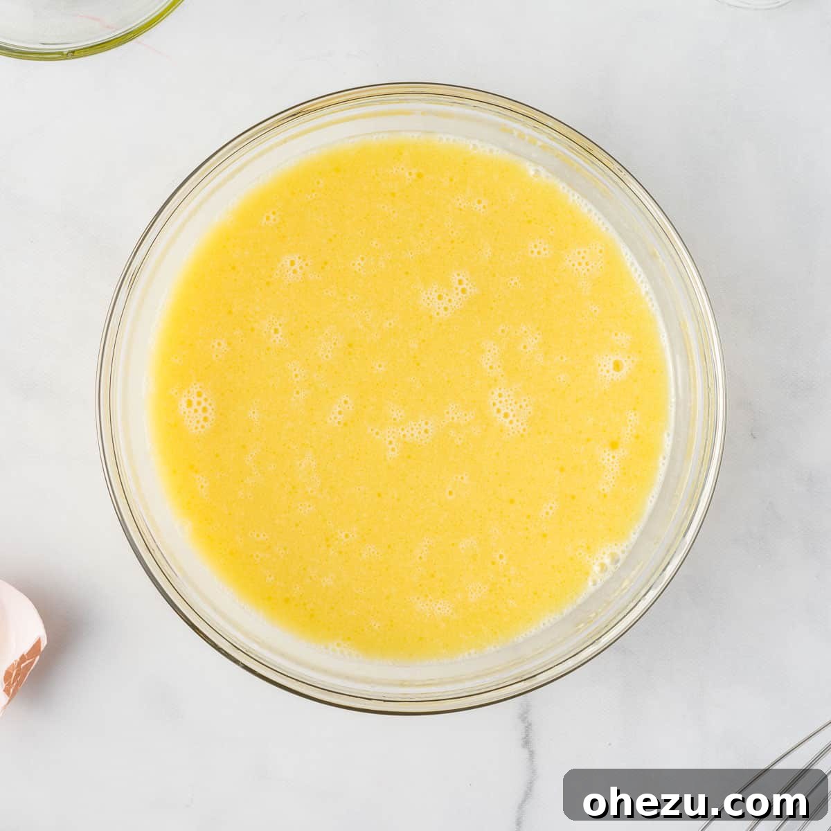 Close-up of perfectly whisked wet ingredients, a smooth yellow mixture, ready for the cake mix